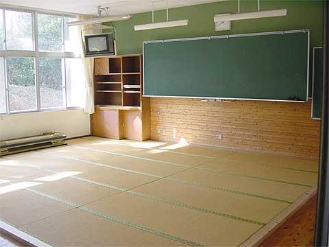 前方に黒板と棚が設置され、畳が18枚敷かれている和教室の写真