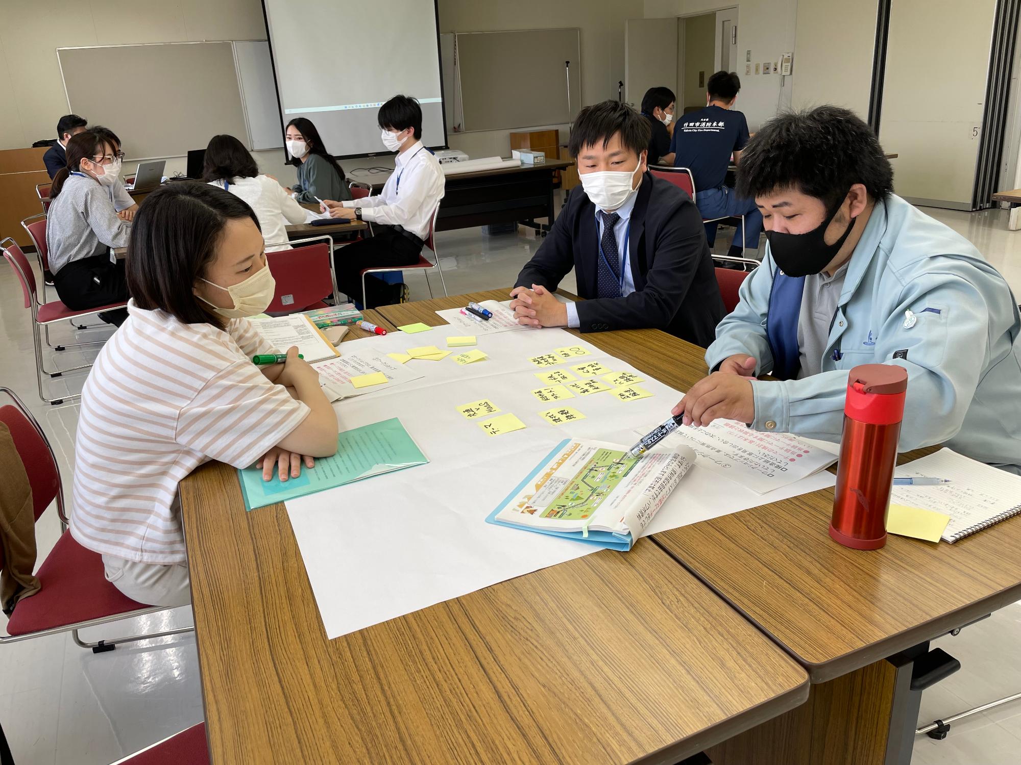 最終回の発表に向けてグループごとに話し合う若手職員