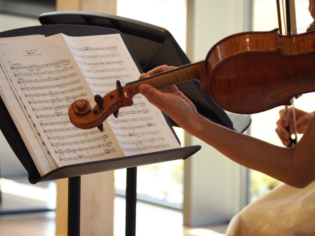 譜面台の楽譜とヴァイオリンの写真