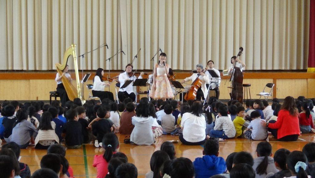 東京アーティスツ合奏団の歌と演奏を聞いている子供達の写真